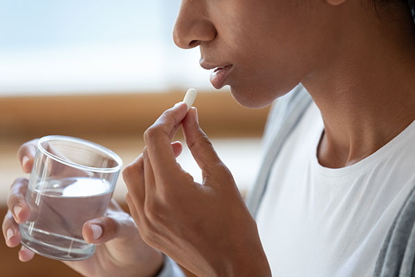 woman taking oral conscious sedation in a pill form