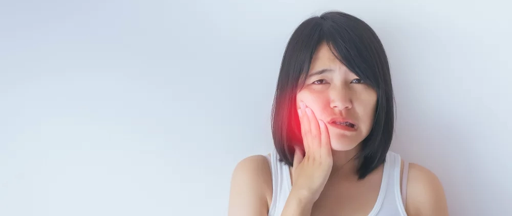 young asian woman feeling jaw pain