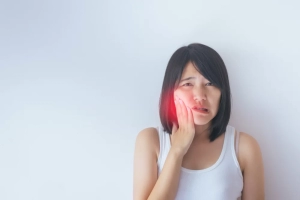 young asian woman feeling jaw pain