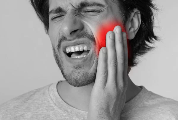 man feeling tooth pain